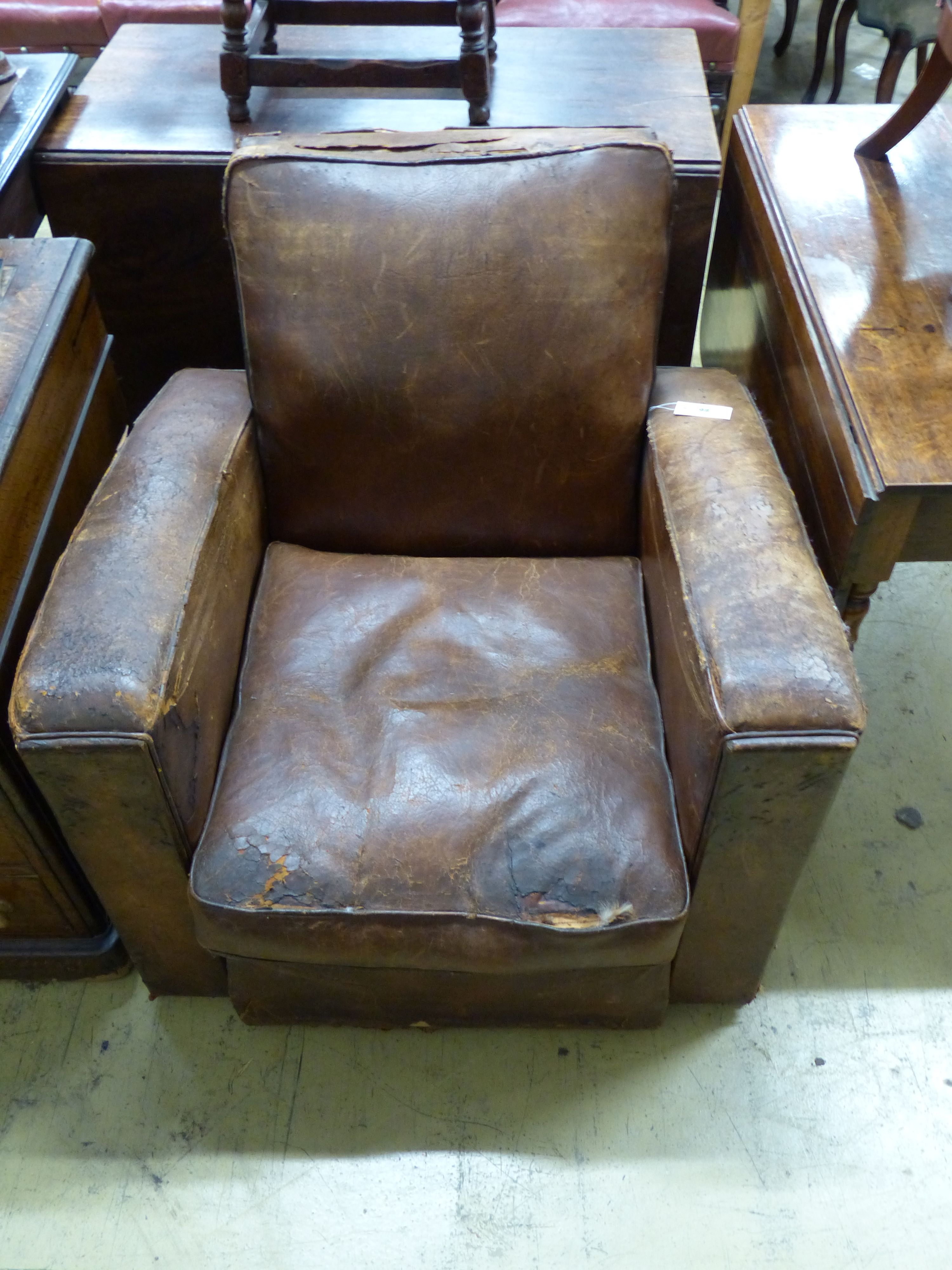 A 1930's French distressed leather club armchair, width 81cm
